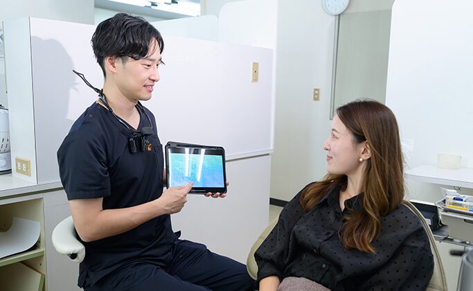 インプラントについて歯科医に質問する患者さん